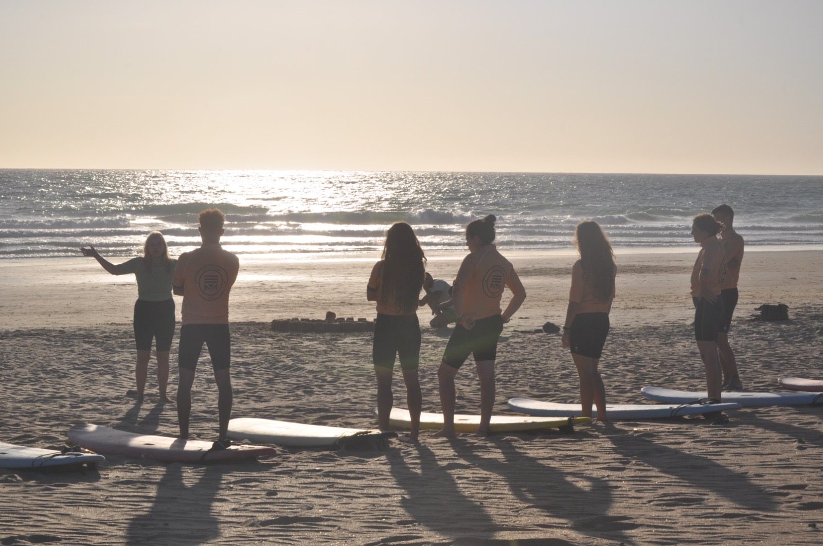 Clase de surf grupal al atardecer en la playa de Zahara de los Atunes