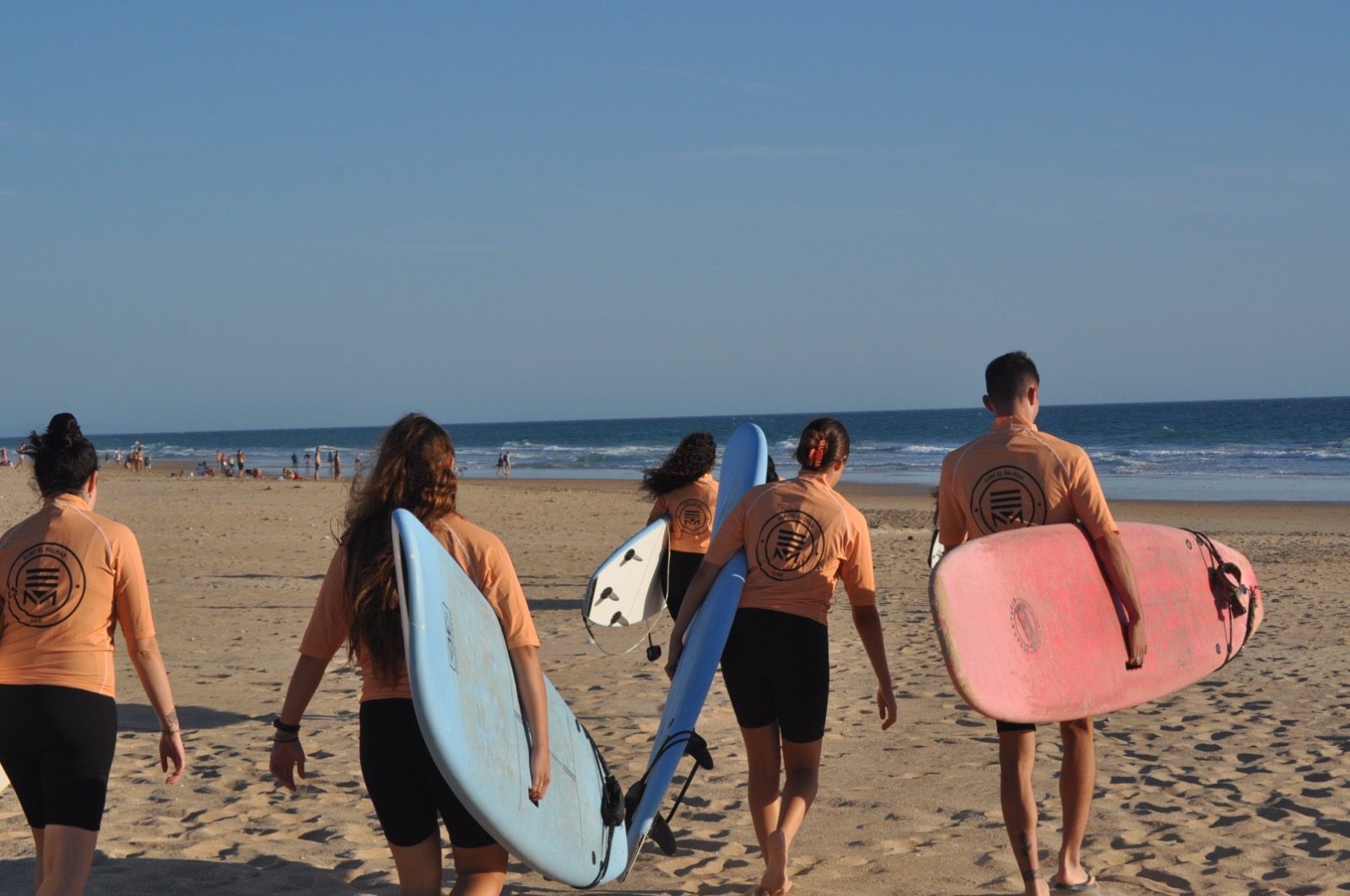 Grupo de alumnos con tablas de surf en la playa de Zahara de los Atunes