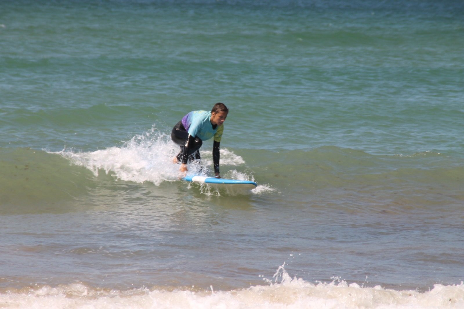 Niño surfeando una ola en la playa de Zahara de los Atunes